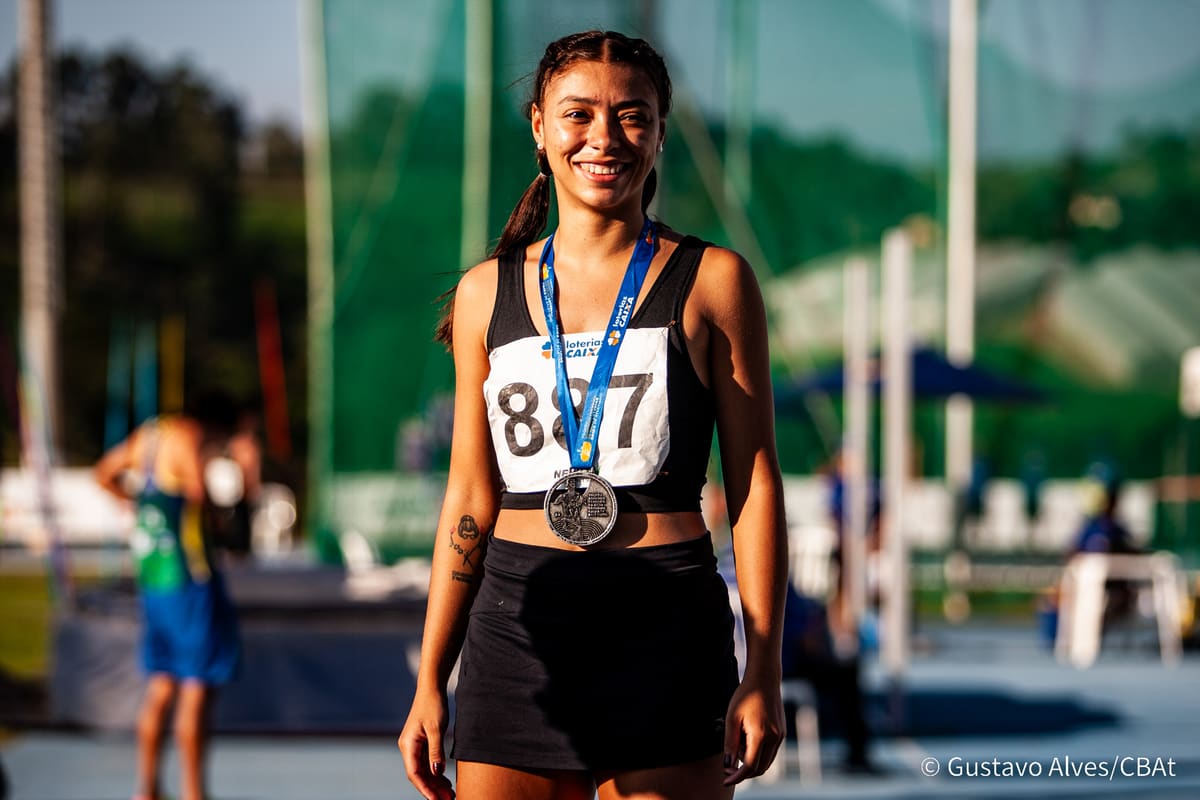 Atleta da Atletismo-UEM com medalha de prata, retrato ao entardecer