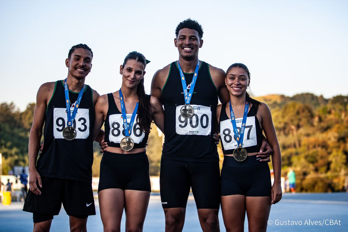 Quatro atletas da Atletismo-UEM posando juntos com medalhas