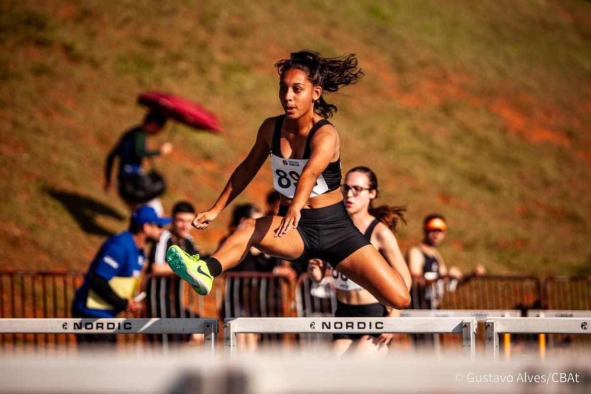 Atleta da Atletismo-UEM saltando uma barreira durante prova de corrida com obstáculos